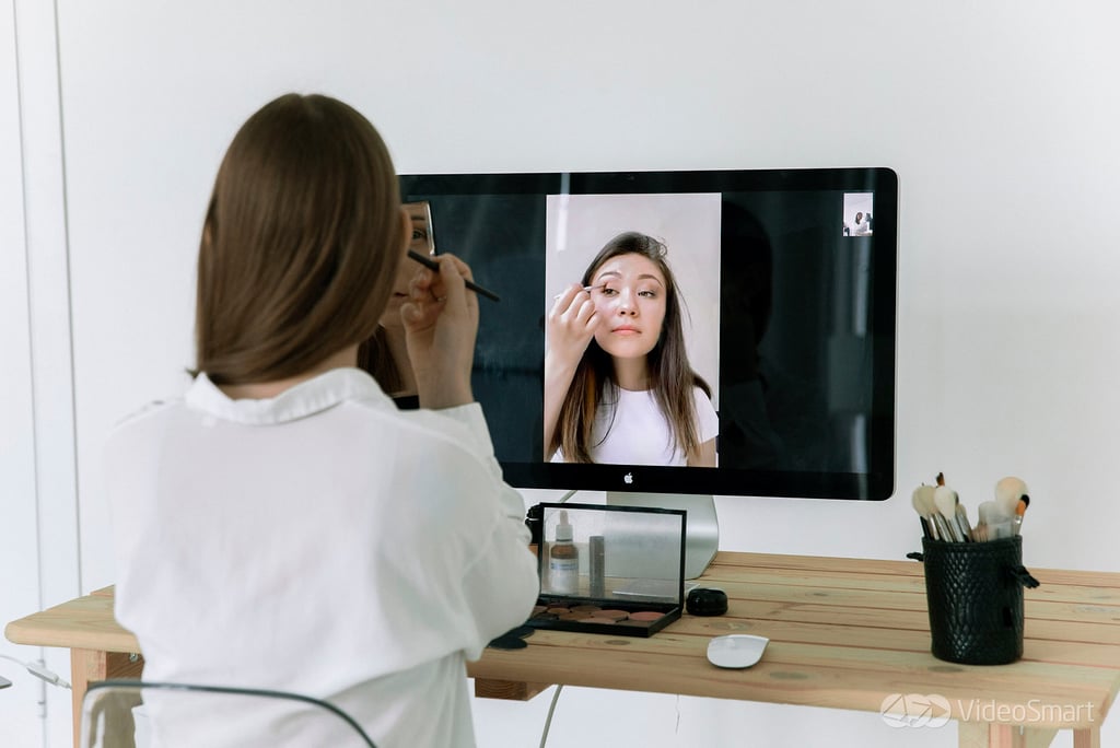 Lady doing her make-up in front of a computer screen.